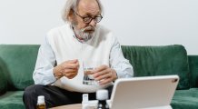 Man met tablet, pillen en een glas water