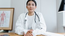 Vrouwelijke arts met stethoscoop aan bureau