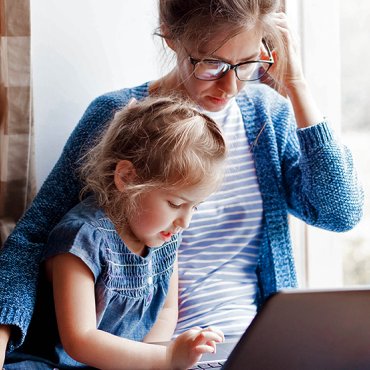 Moeder en dochtertje kijken op laptop