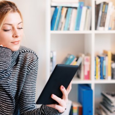 Jonge vrouw leest boek op e-reader